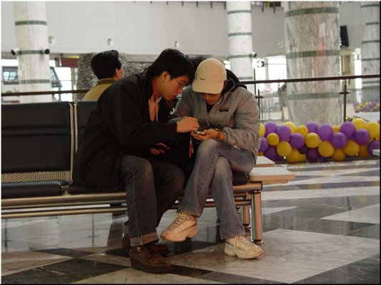 01-04-05 Meimei and Hsin-Mu checking a PDA in Hualien Airport on way back.jpg